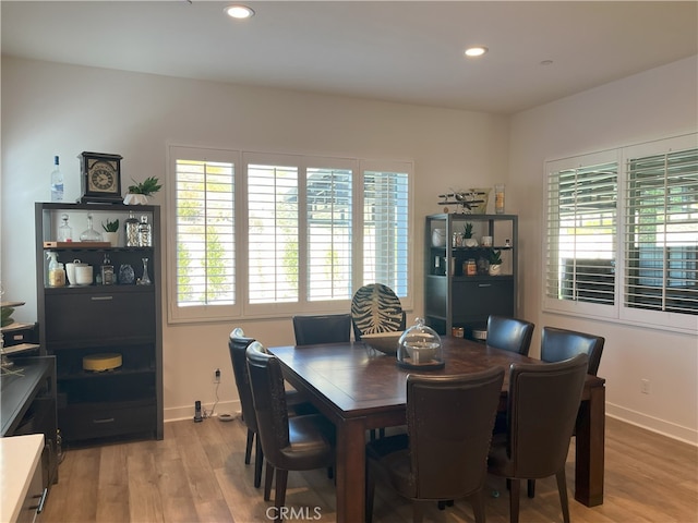 dining space featuring baseboards, light wood-style flooring, and recessed lighting