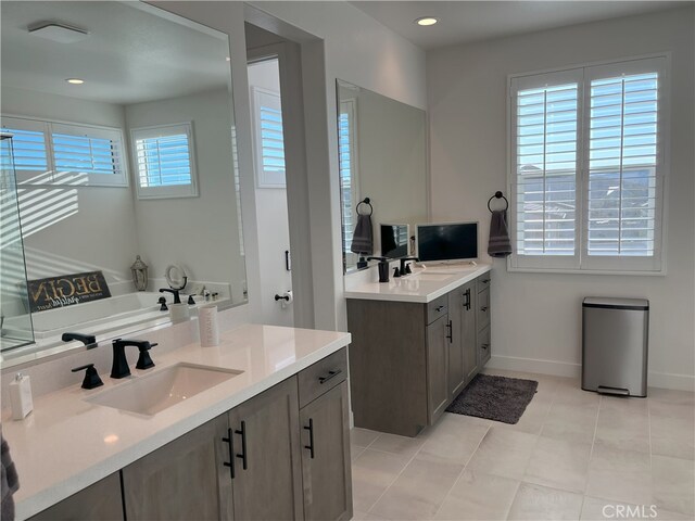 bathroom featuring tile patterned floors, vanity, and a bath