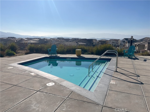 view of pool featuring a patio, a residential view, a mountain view, and a fenced in pool