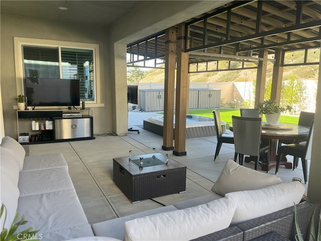 view of patio with a hot tub, fence, outdoor lounge area, and outdoor dining space