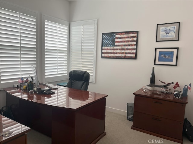 carpeted home office featuring baseboards