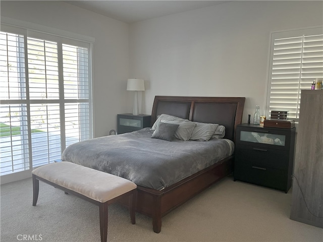 carpeted bedroom featuring multiple windows