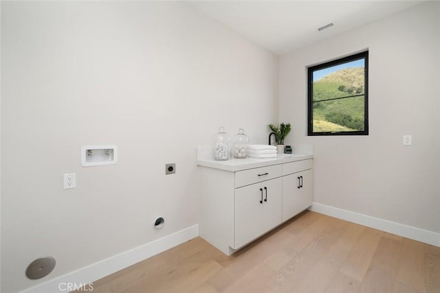 laundry room with washer hookup, electric dryer hookup, and light hardwood / wood-style flooring