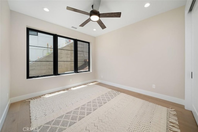 empty room featuring ceiling fan and light hardwood / wood-style flooring