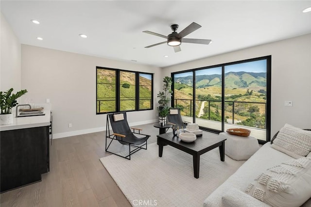 living room featuring ceiling fan and hardwood / wood-style flooring