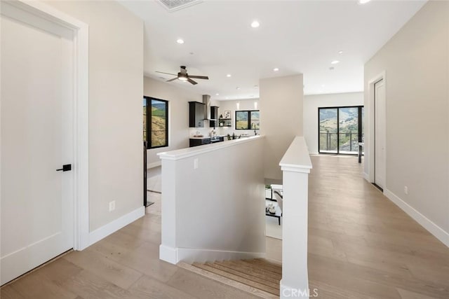 corridor with light hardwood / wood-style floors