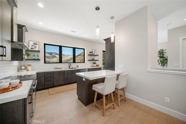 kitchen with decorative light fixtures, a kitchen breakfast bar, backsplash, and kitchen peninsula