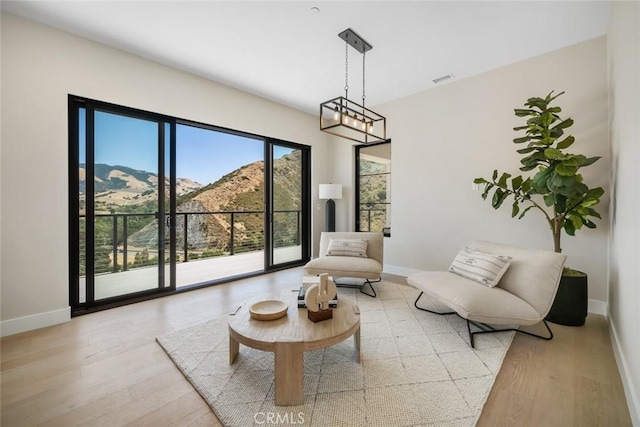 sitting room with a mountain view and light hardwood / wood-style floors