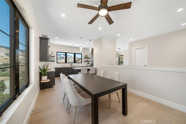 dining space with light hardwood / wood-style floors, sink, and ceiling fan