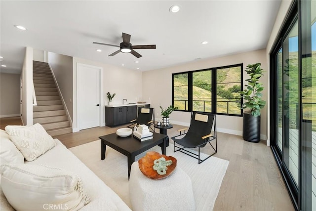 living room with light wood-type flooring and ceiling fan