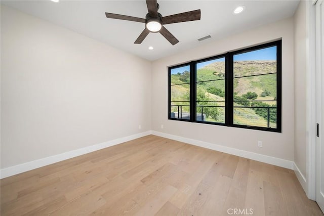 spare room with ceiling fan and light hardwood / wood-style floors