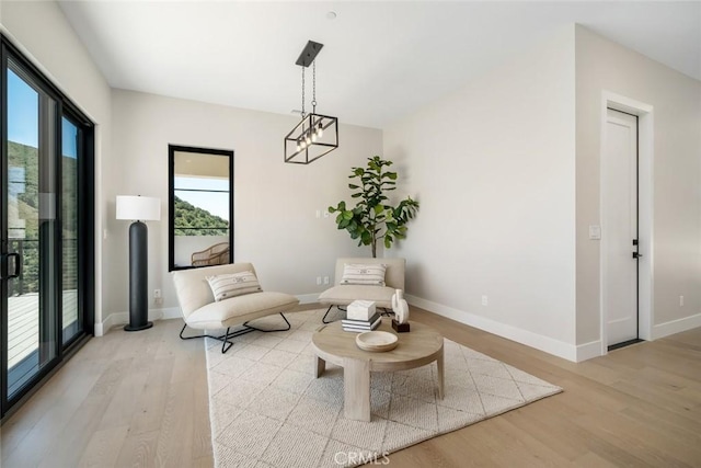 sitting room with light wood-type flooring and a notable chandelier