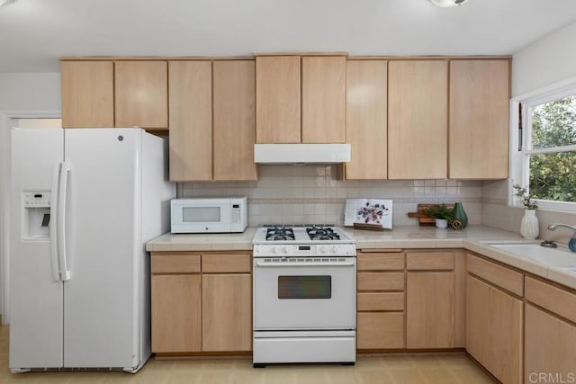 kitchen with light brown cabinets, backsplash, white appliances, range hood, and sink