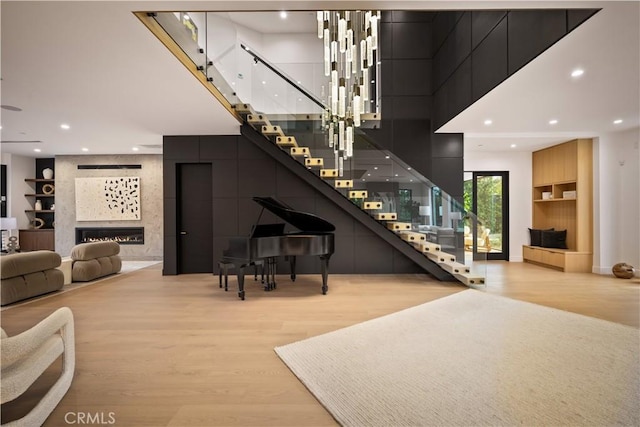 stairway with built in features, a fireplace, and hardwood / wood-style flooring