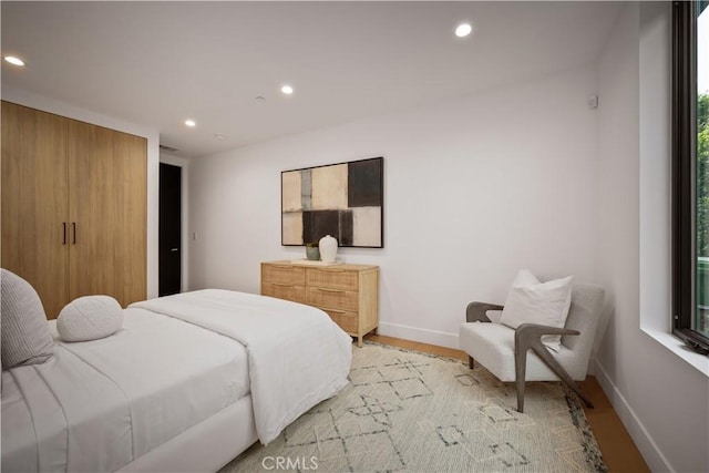 bedroom with multiple windows and light hardwood / wood-style flooring