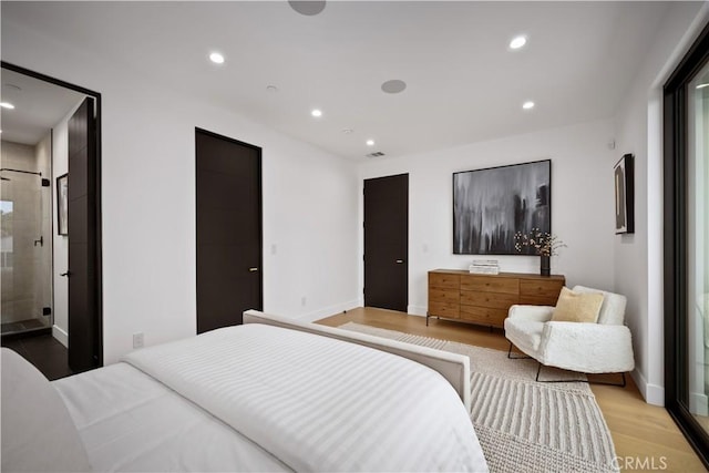 bedroom featuring ensuite bathroom and light hardwood / wood-style flooring