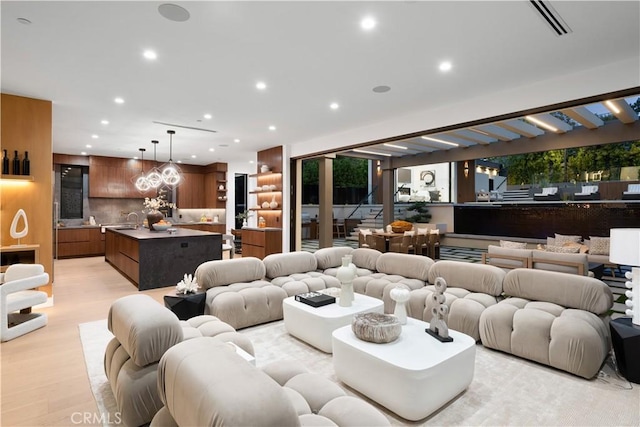 living room with light hardwood / wood-style floors and sink