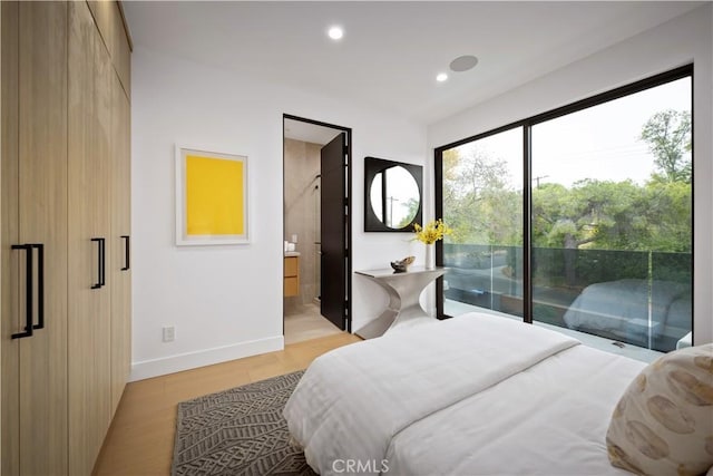 bedroom featuring ensuite bathroom, light wood-type flooring, and access to outside