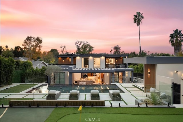 back house at dusk with a patio area