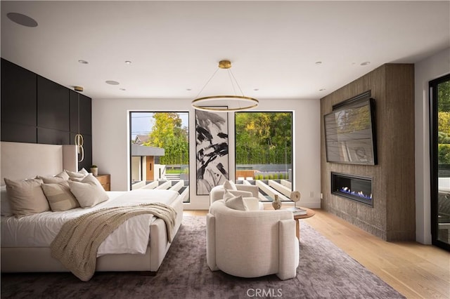 bedroom featuring a large fireplace and light hardwood / wood-style floors