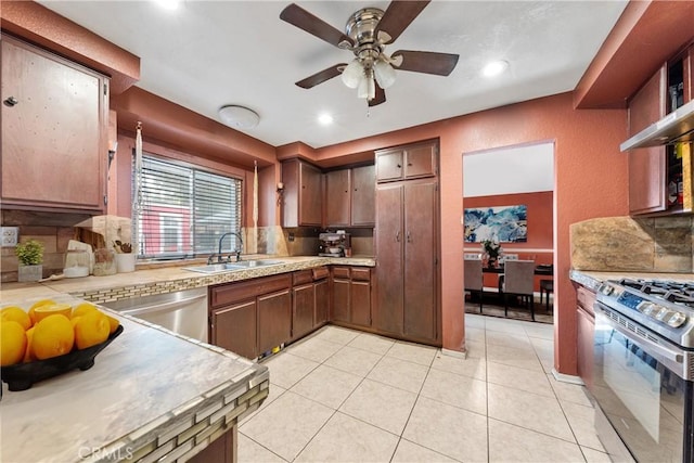 kitchen with tasteful backsplash, ceiling fan, sink, light tile patterned flooring, and stainless steel appliances