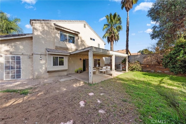 rear view of house with a patio area and a yard