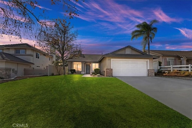 view of front of property with a garage and a yard