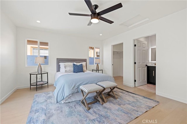 bedroom featuring ceiling fan, a walk in closet, a closet, and light hardwood / wood-style flooring