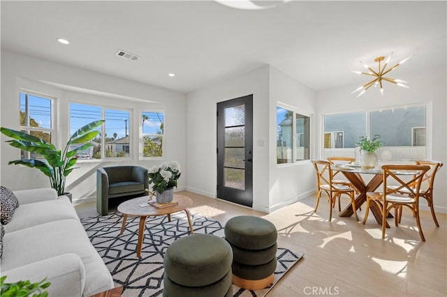 living room featuring light hardwood / wood-style flooring and a notable chandelier