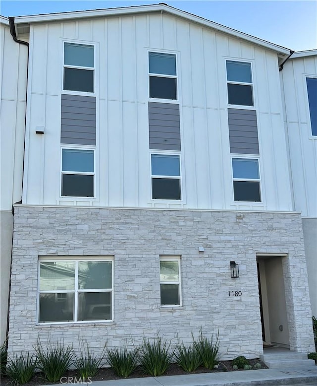 view of side of home with stone siding and board and batten siding