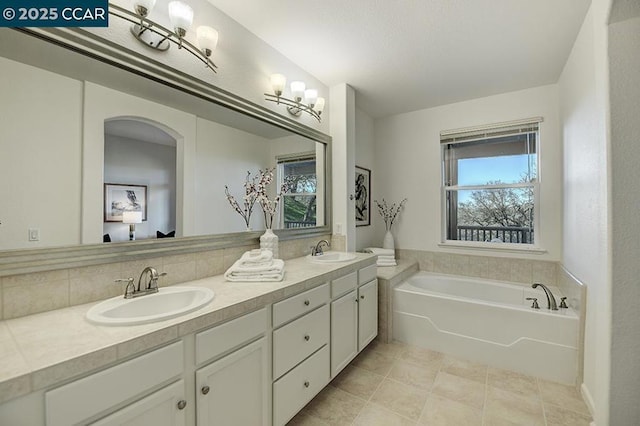 bathroom featuring a bath, tile patterned floors, and vanity