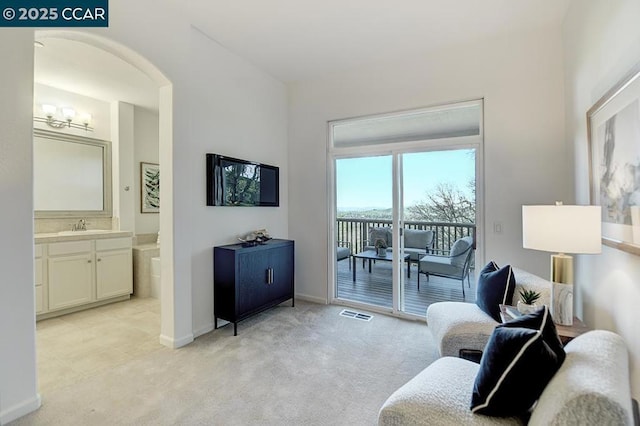 living area with light carpet, an inviting chandelier, and sink