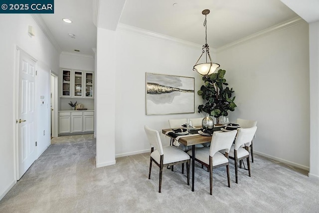 carpeted dining space featuring crown molding