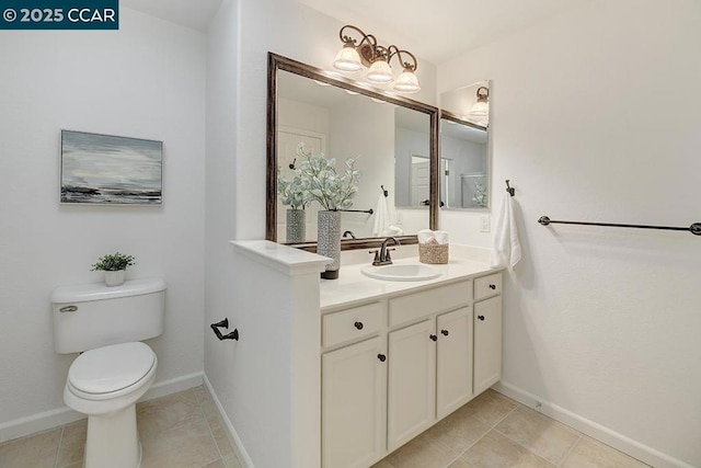 bathroom featuring toilet, vanity, and tile patterned flooring