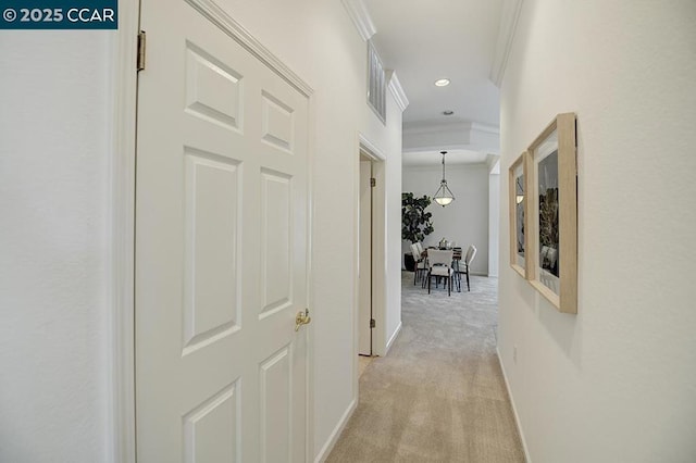 hall with light colored carpet and ornamental molding