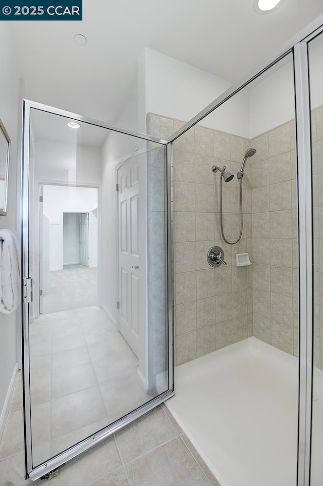 bathroom with a tile shower and tile patterned floors