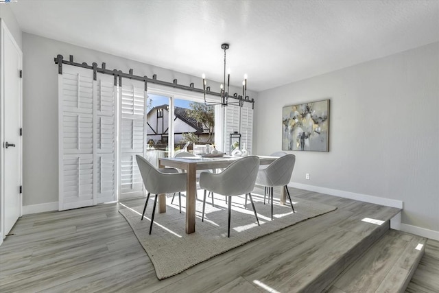 dining area with hardwood / wood-style flooring and a notable chandelier