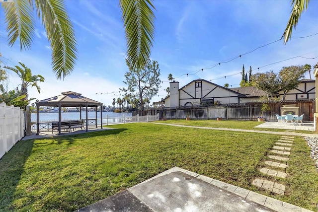 view of yard featuring a patio, a gazebo, and a water view