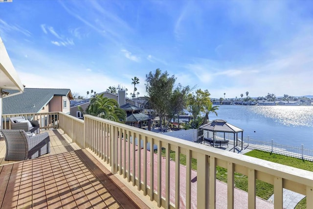 wooden deck with a water view and a gazebo