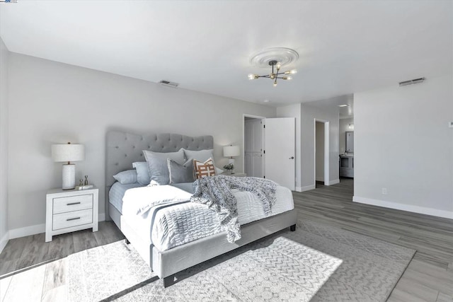 bedroom featuring hardwood / wood-style floors and a notable chandelier