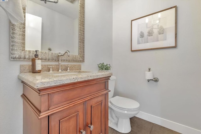 bathroom with toilet, vanity, and tile patterned flooring