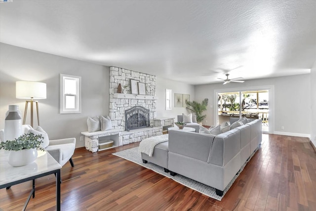 living room with ceiling fan, dark wood-type flooring, and a fireplace