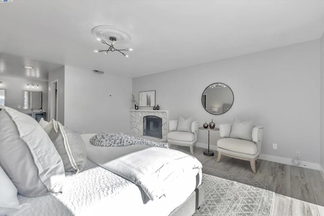 living room featuring an inviting chandelier, a fireplace, and wood-type flooring