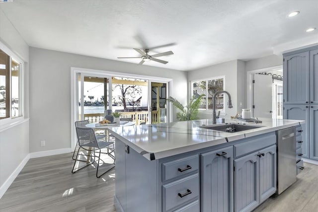 kitchen with dishwasher, a kitchen island with sink, ceiling fan, plenty of natural light, and sink