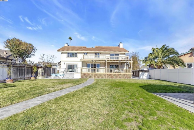 rear view of property with a balcony and a lawn