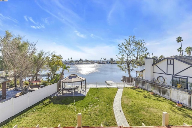 view of yard with a boat dock, a water view, and a gazebo