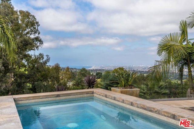 view of swimming pool featuring a hot tub