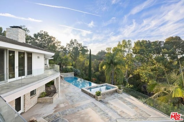 view of pool featuring an in ground hot tub and a patio