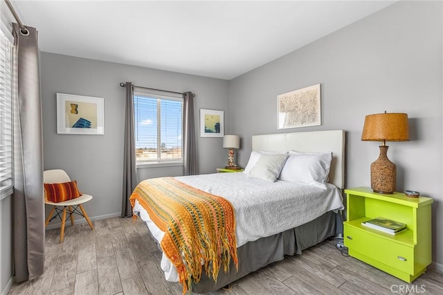 bedroom with wood finished floors and baseboards