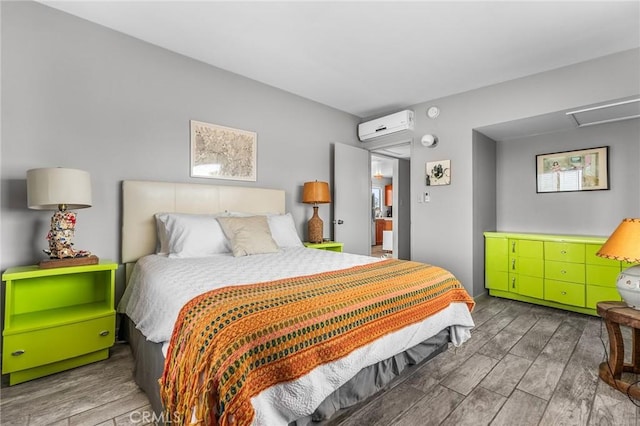 bedroom featuring a wall unit AC and wood finished floors